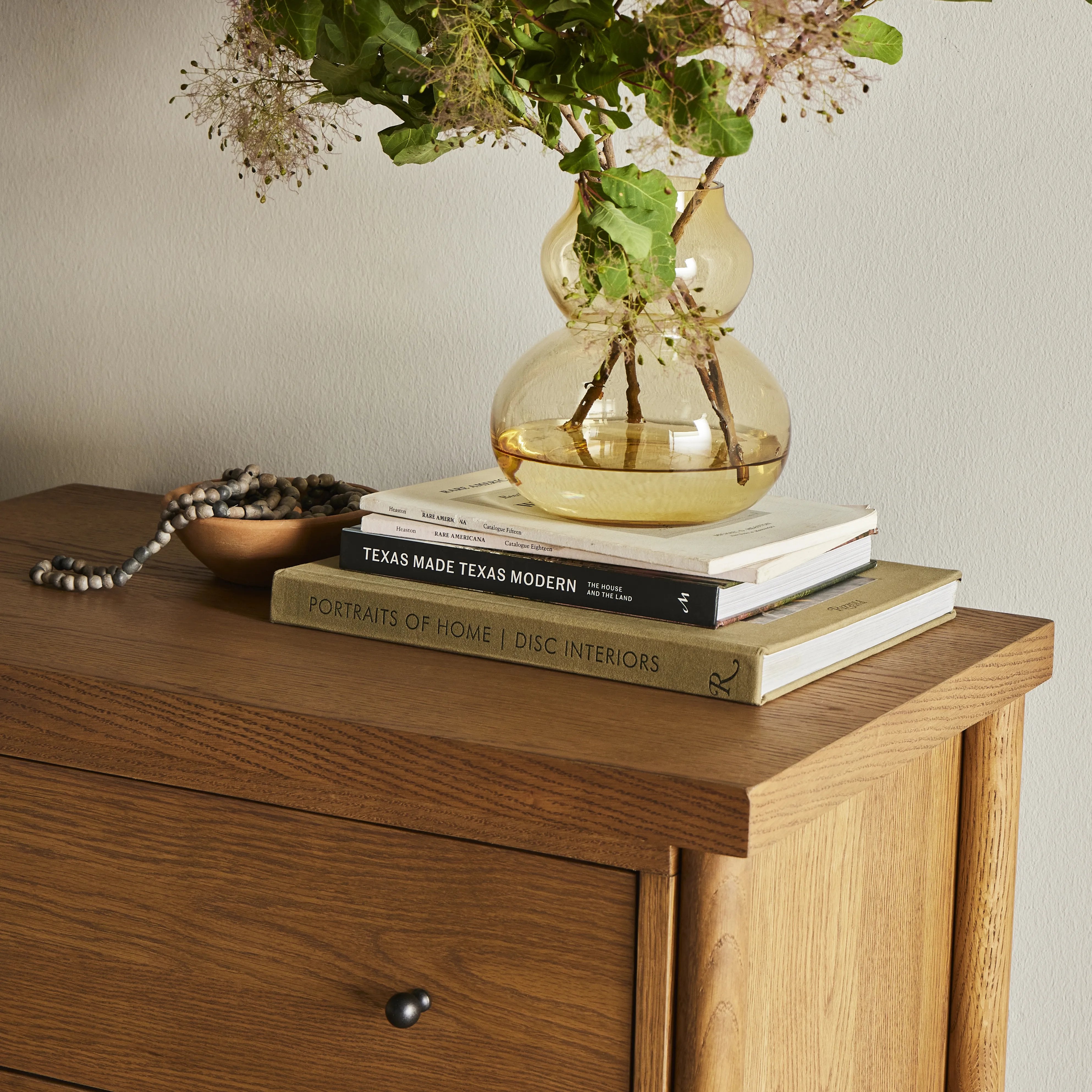 Rounded, chunky dowel legs in an amber oak finish support the overhang top of of this nightstand. Two drawers provide ample storage, finished with simple gunmetal hardware Amethyst Home provides interior design, new home construction design consulting, vintage area rugs, and lighting in the Newport Beach metro area.