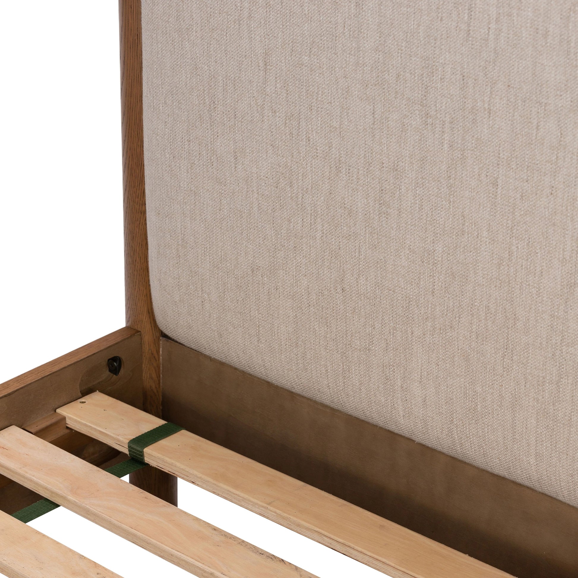 Rounded, chunky dowel legs in an amber oak finish frame the neutral, linen-like upholstered headboard of this bed frame Amethyst Home provides interior design, new home construction design consulting, vintage area rugs, and lighting in the Boston metro area.