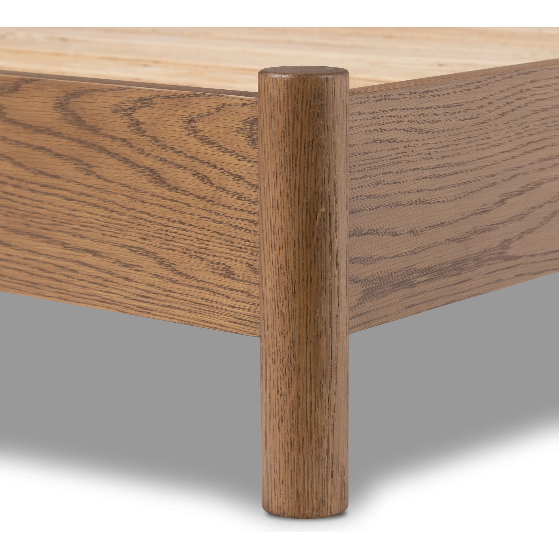 Rounded, chunky dowel legs in an amber oak finish frame the neutral, linen-like upholstered headboard of this bed frame Amethyst Home provides interior design, new home construction design consulting, vintage area rugs, and lighting in the Dallas metro area.