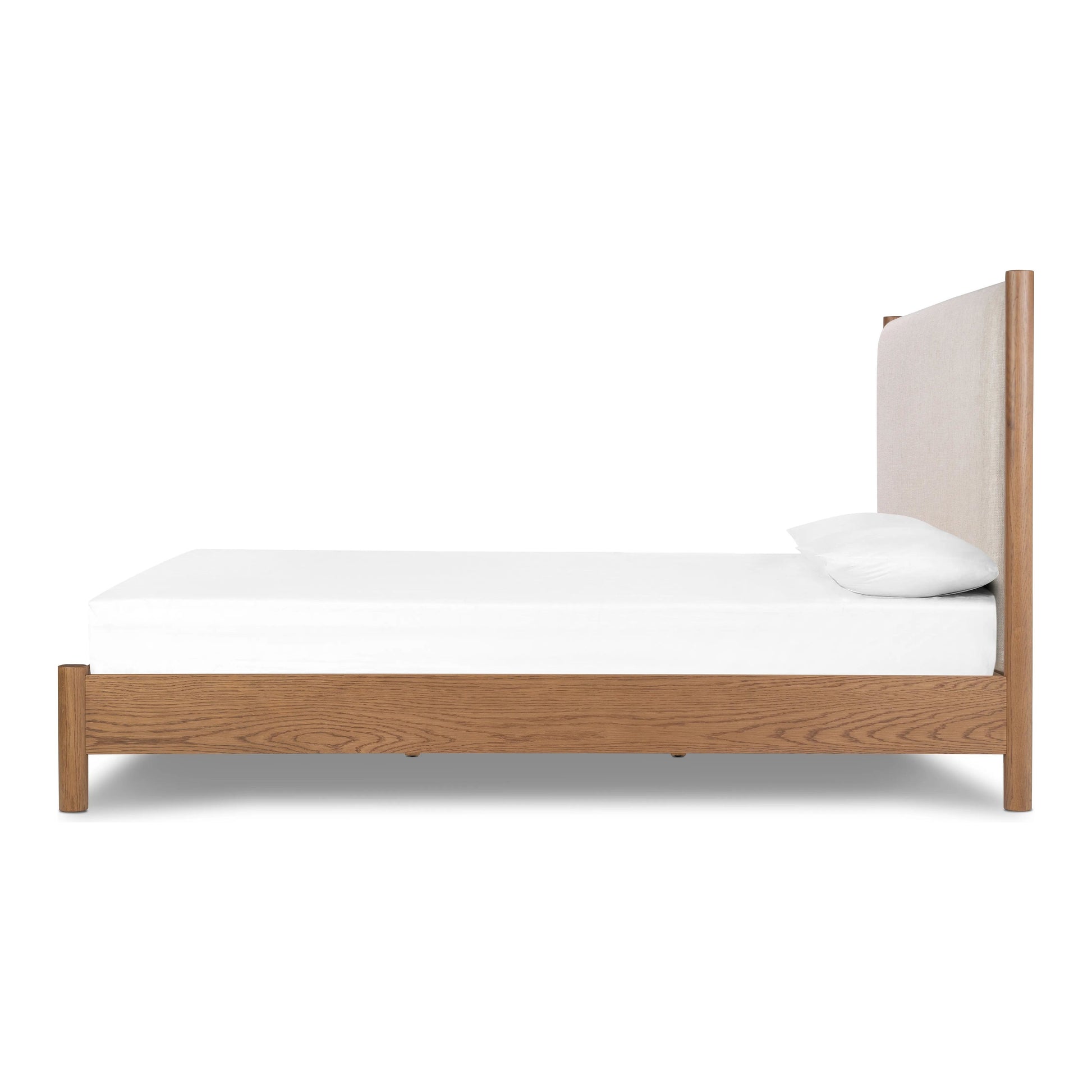 Rounded, chunky dowel legs in an amber oak finish frame the neutral, linen-like upholstered headboard of this bed frame Amethyst Home provides interior design, new home construction design consulting, vintage area rugs, and lighting in the San Diego metro area.