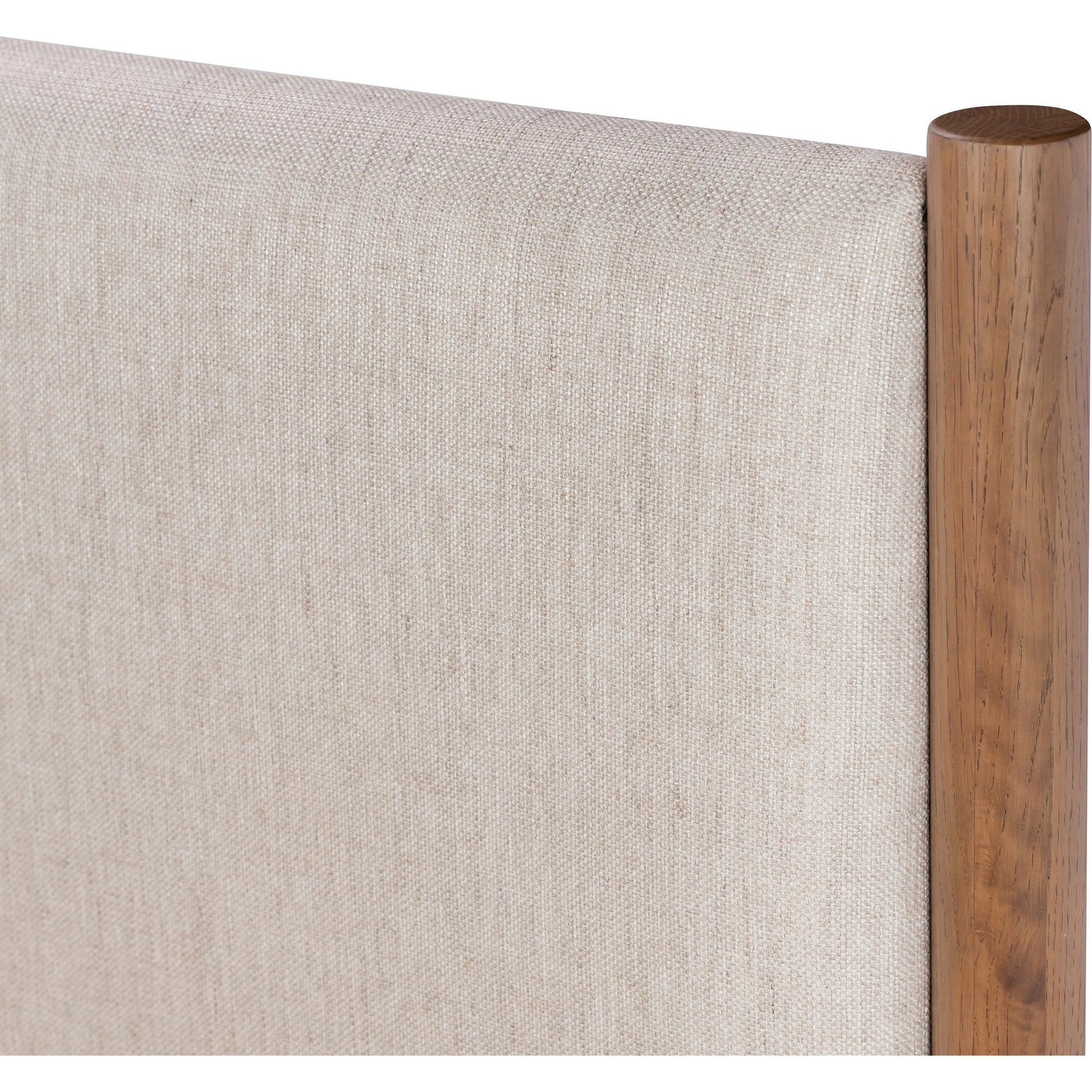Rounded, chunky dowel legs in an amber oak finish frame the neutral, linen-like upholstered headboard of this bed frame Amethyst Home provides interior design, new home construction design consulting, vintage area rugs, and lighting in the Seattle metro area.