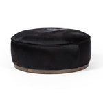 This large, round ottoman of textural hair-on hide brings with it a hip retro vibe as a coffee table or extra seating.  Covered in soft and luminous black hair-on hide, which is naturally warm and textural with authentic highlights. Amethyst Home provides interior design, new construction, custom furniture, and area rugs in the Washington metro area.