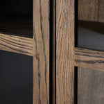 This minimal-inspired bookcase is crafted from a mix of solid oak and worn oak veneer. Featuring glass-front doors and spacious shelves for storage and display.Collection: Bennet Amethyst Home provides interior design, new home construction design consulting, vintage area rugs, and lighting in the Tampa metro area.