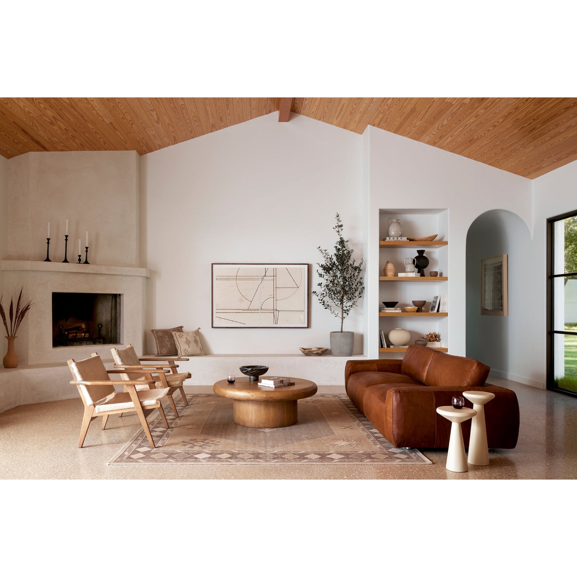 The Zach coffee table in burnished parawood features a pedestal-style base on a rounded tabletop with bullnose edging, for style and softness alike. Amethyst Home provides interior design, furniture, rugs, and design services in the Des Moines metro area.
