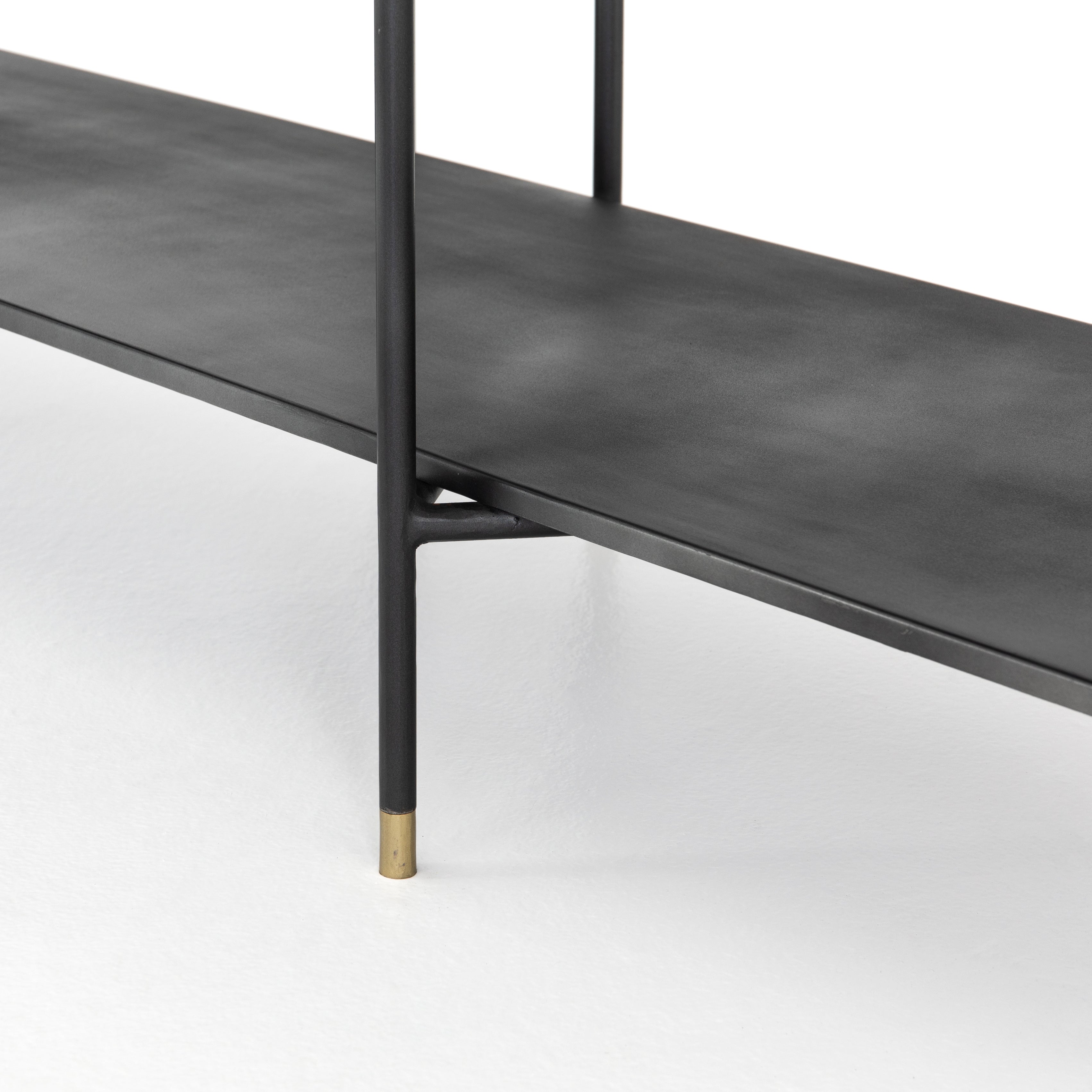 Modern industrial design gets softened by fine lines with this Vito Bookshelf. Wide planks of distressed iron offer plenty of space for the display of books and treasured items. Brass-capped feet add a feminine finishing touch.  Available September 2020!  Overall Dimensions: 63"w x 16.5"d x 71"h Materials: Iron