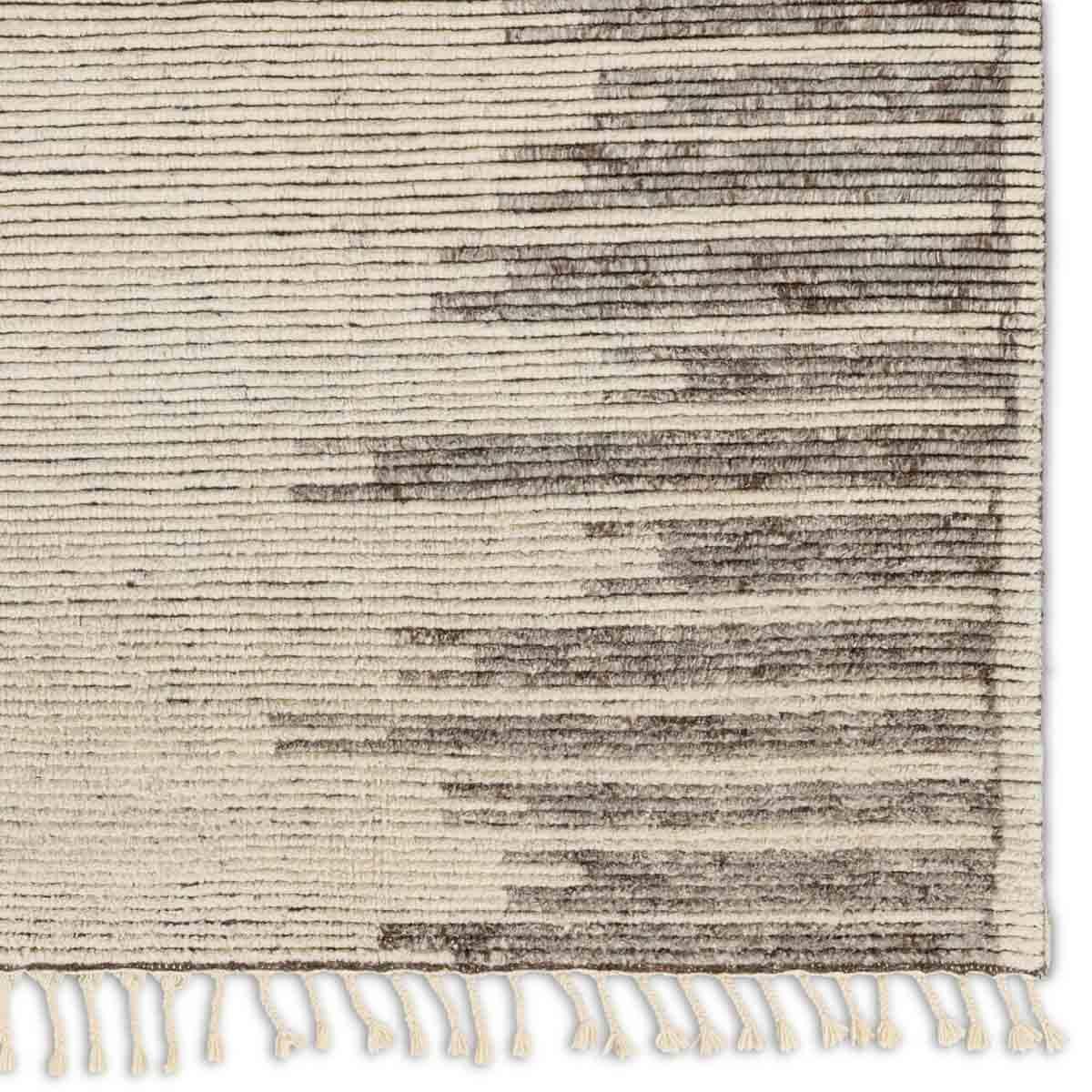 Inspired by textiles from the Tullu region in Morocco, the Patra area rug showcases a linear design in neutral shades of cream, taupe, brown, and gray. This high-piled accent lends warmth and comfort to any space with durable wool hand-knotted onto a cotton foundation. Braided fringe trims the edges for a touch of boho charm. Amethyst Home provides interior design, new home construction design consulting, vintage area rugs, and lighting in the Charlotte metro area.