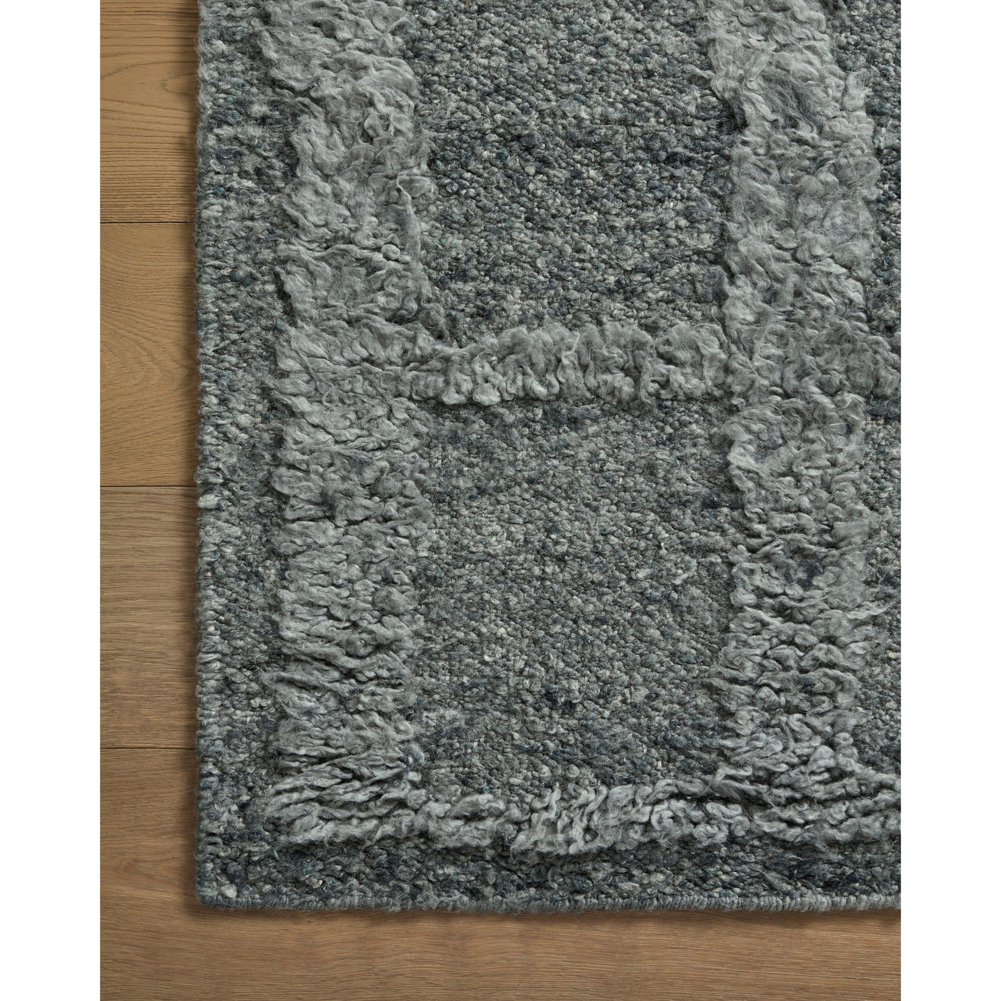The Cassian Denim rug is a hand-woven wool and cotton area rug with an asymmetrical gridded pattern and high-low texture. The rug’s higher, shaggy pile takes cues from Moroccan designs, while the neutral colors and natural materials make it a cozy addition to any space, especially living rooms and dens. Amethyst Home provides interior design, new home construction design consulting, vintage area rugs, and lighting in the Omaha metro area.