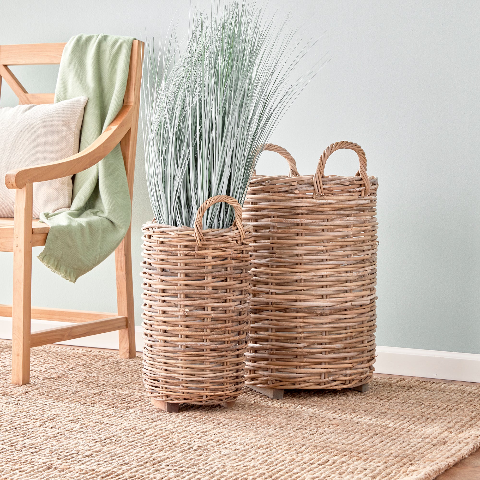 Made of a thick, woven rattan this set of two tall baskets are made to last. Furnished with a plastic liner to protect, and teak feet adding stability and elevating from the floor keeping them dry. Just as smart as they are beautiful. Amethyst Home provides interior design, new construction, custom furniture, and area rugs in the Alpharetta metro area.