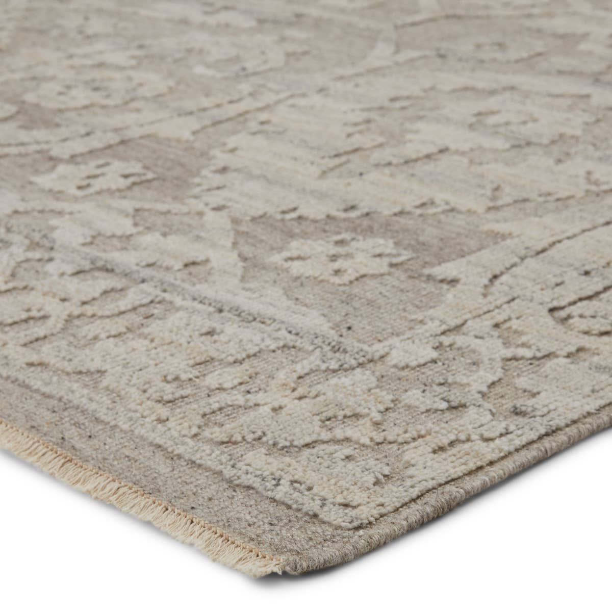 The Sonnette Ayres Area Rug by Jaipur Living, or SNN03, boasts a neutral palette of light taupe and gray that creates beautiful dimension among the brocade design. This hand-knotted wool rug features fringe trimmed details for a touch of global charm. A gorgeous choice for your bedroom or other medium traffic areas. 