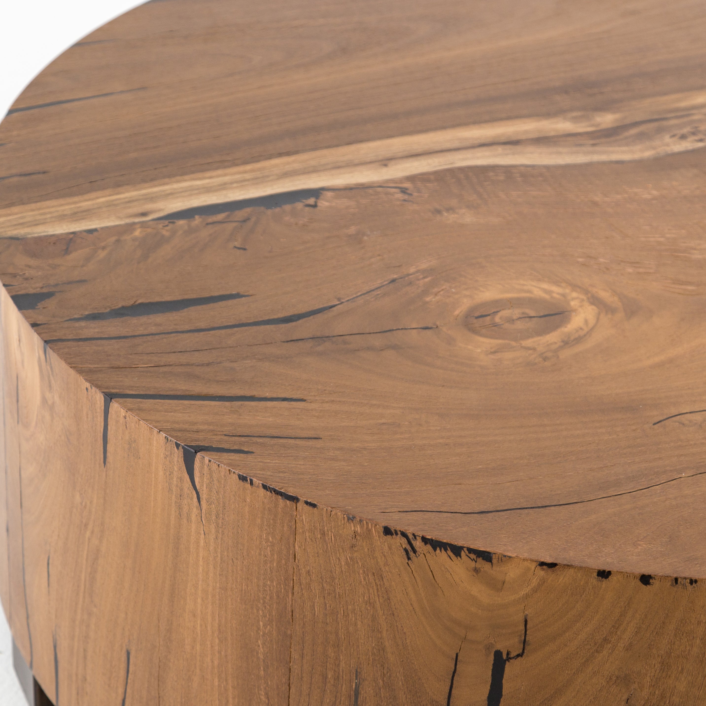 Stunning forces of nature are captured in the Hudson Coffee Table. We love how the palted primavera wood is hand-shaped into a cylindrical silhouette.   Overall Dimensions: 40"w x 40"d x 15"h  Materials: Yukas, Iron Materials: Iron, Primavera Materials: Iron, Thick Walnut Veneer