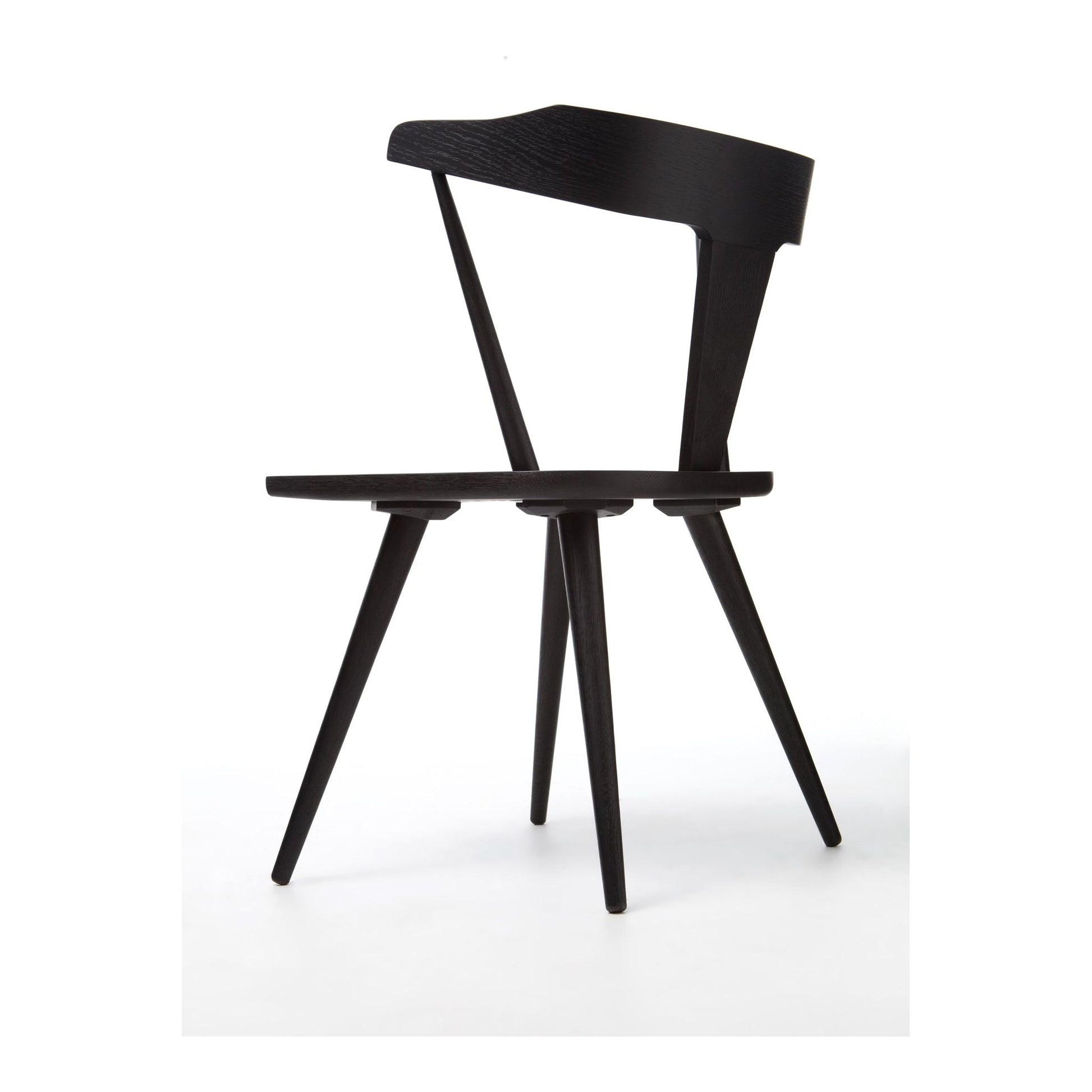 This new take on the mid-century Windsor chair, the Ripley Dining Chair has a bowed, sculptural silhouette. A soft black finish adds movement to the wood by highlighting the natural grain of weathered oak. The chair is perfect for the chic, modern dining room look.