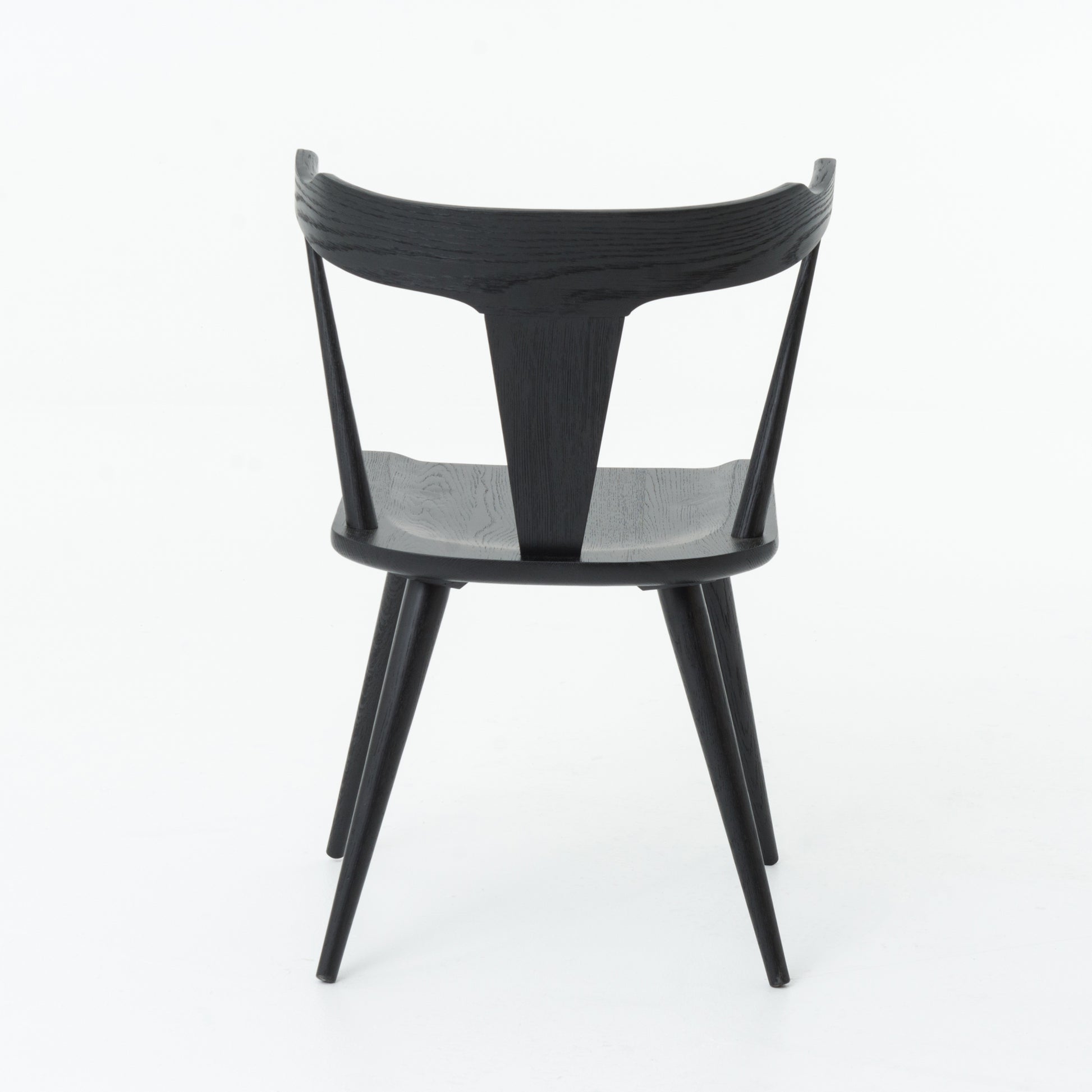 This new take on the mid-century Windsor chair, the Ripley Dining Chair has a bowed, sculptural silhouette. A soft black finish adds movement to the wood by highlighting the natural grain of weathered oak. The chair is perfect for the chic, modern dining room look.