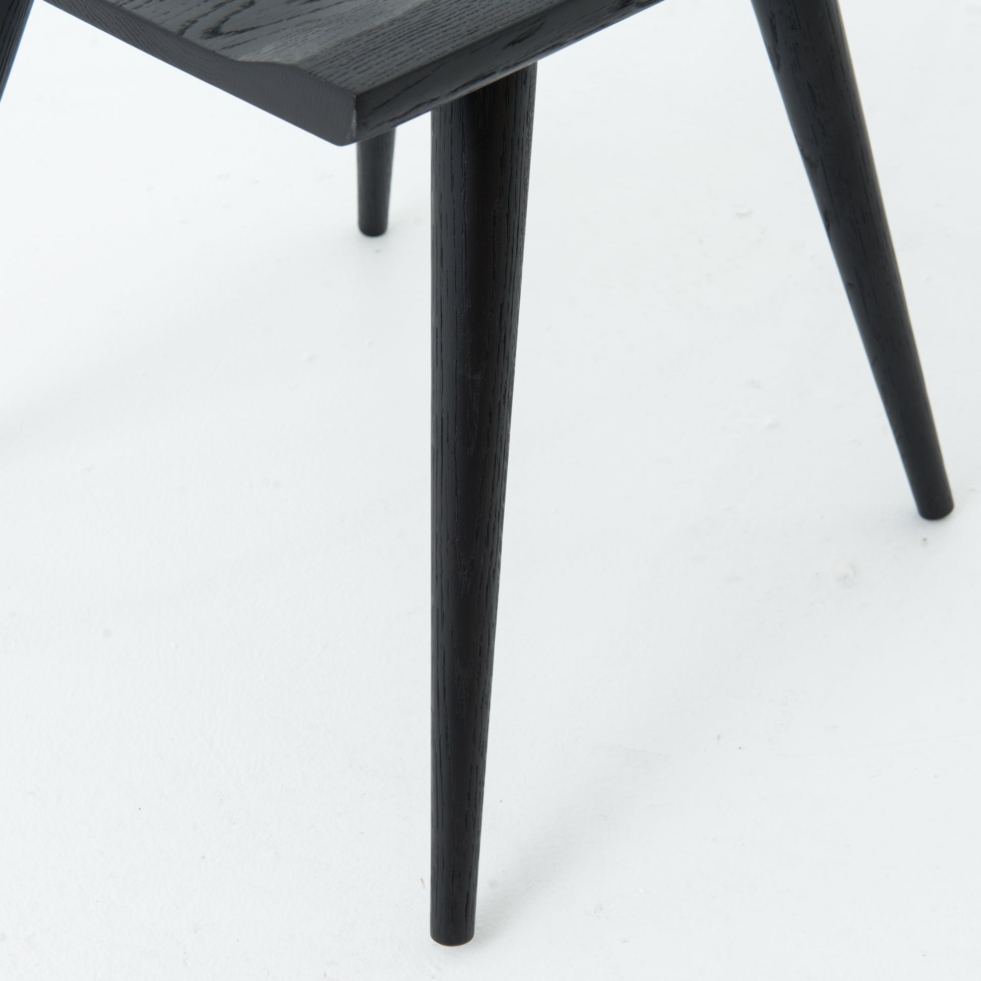 This new take on the mid-century Windsor chair, the Ripley Dining Chair has a bowed, sculptural silhouette. A soft black finish adds movement to the wood by highlighting the natural grain of weathered oak. The chair is perfect for the chic, modern dining room look.