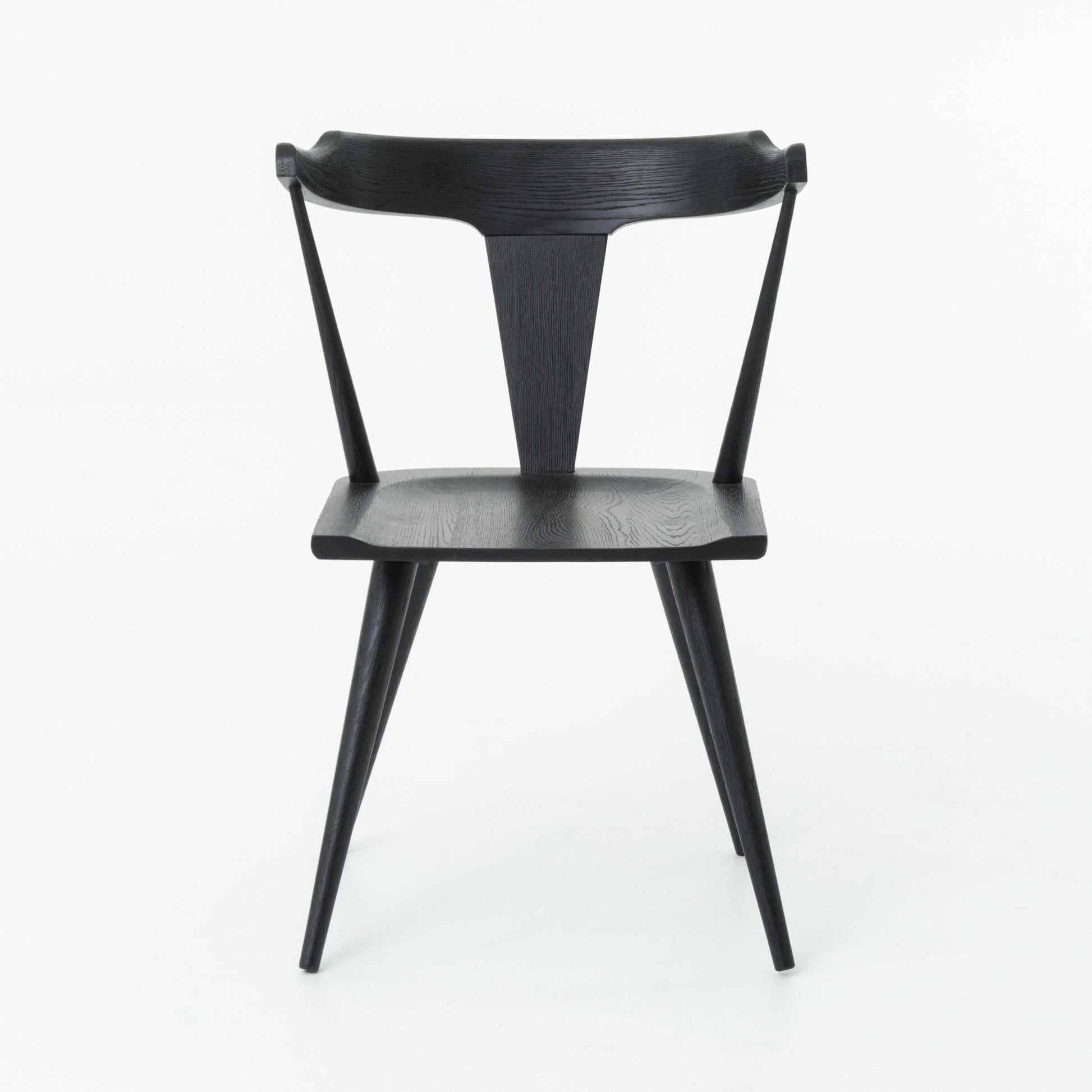 This new take on the mid-century Windsor chair, the Ripley Dining Chair has a bowed, sculptural silhouette. A soft black finish adds movement to the wood by highlighting the natural grain of weathered oak. The chair is perfect for the chic, modern dining room look.