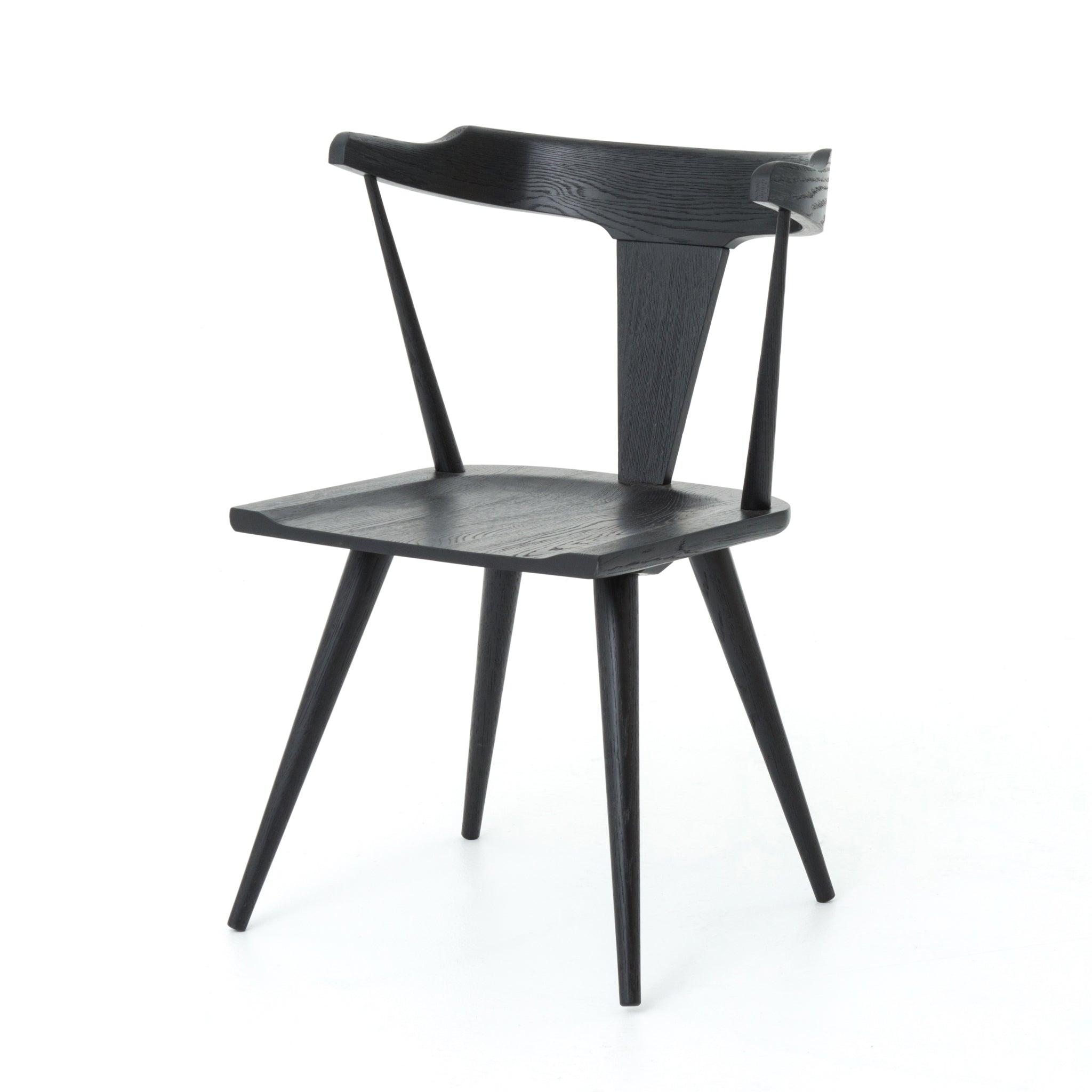 This new take on the mid-century Windsor chair, the Ripley Dining Chair has a bowed, sculptural silhouette. A soft black finish adds movement to the wood by highlighting the natural grain of weathered oak. The chair is perfect for the chic, modern dining room look.