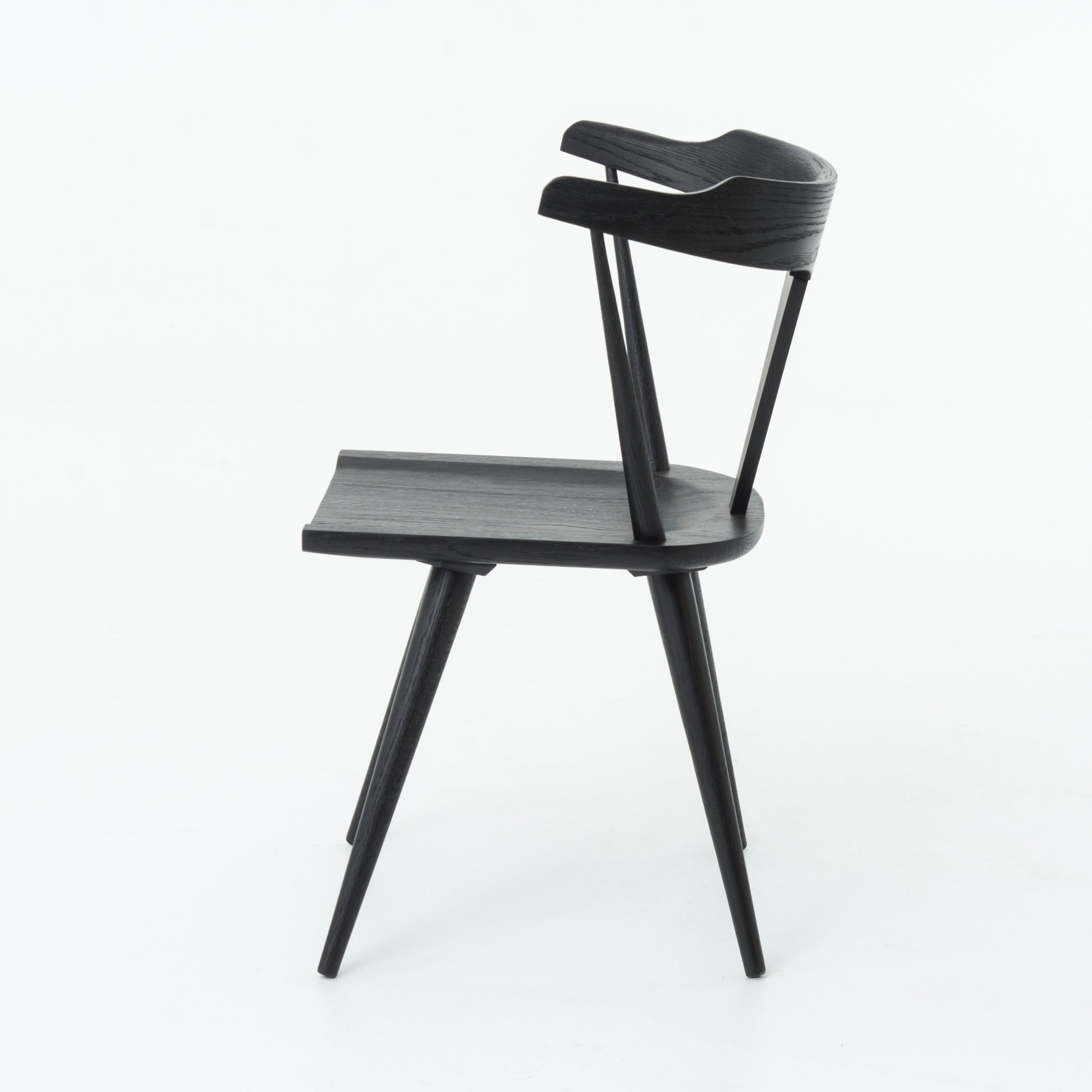 This new take on the mid-century Windsor chair, the Ripley Dining Chair has a bowed, sculptural silhouette. A soft black finish adds movement to the wood by highlighting the natural grain of weathered oak. The chair is perfect for the chic, modern dining room look.