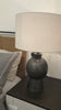 Textured black aluminum forms a shapely base to beautifully complement a white silk shade with this Kelita Table Lamp - Textured Black Alu. A beautiful lamp to place next your bed, sofa, or other area needing extra light.   Overall Dimensions: 16.00"w x 16.00"d x 25.00"h