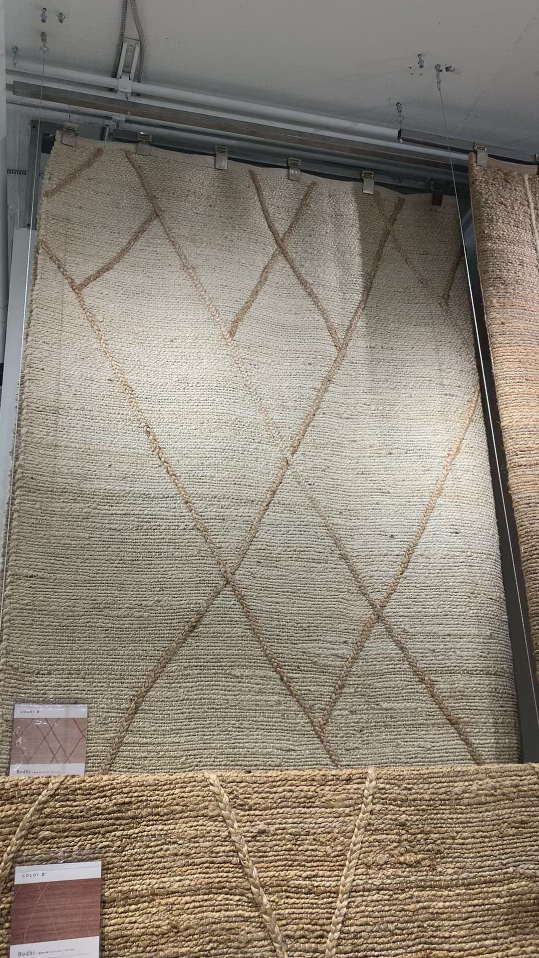 Load video: A tonal approach to Moroccan-inspired rugs, the Bodhi Ivory / Natural BOD-01 rug from Loloi is hand-woven of 100% jute. This rug features linear and braided details, creating natural variations that make a subtle yet striking statement for an entryway, living room, hallway or kitchen runner, or dining room. Amethyst Home provides interior design, new construction, custom furniture, and rugs for the Omaha and Lincoln, Nebraska metro area.