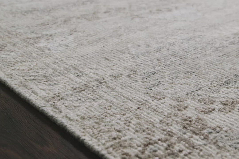The Idris Stone area rug from Loloi is meticulously hand-knotted of viscose and wool. You will love this rug because the rug is:  Perfect for entryways, living rooms, and bedrooms Easy to clean and maintain Gorgeous with the intricate pattern and patina Warms up any room with the high / low pile Hand-Knotted 70% Viscose | 30% Wool ID-01 Stone