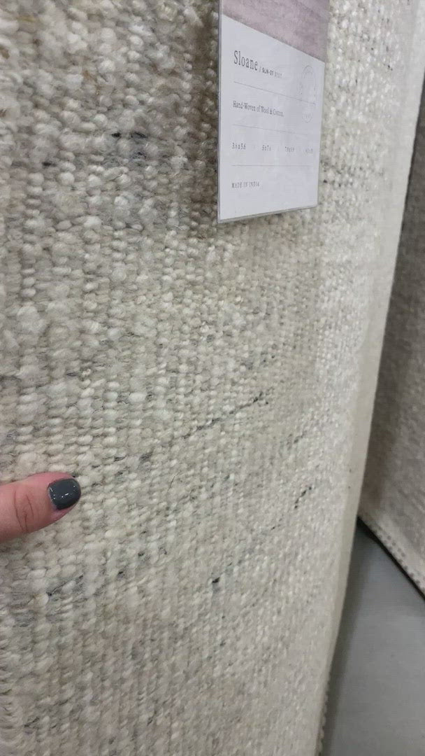 Load video: A perfect blend of refined and relaxed, the Sloane Collection is hand-woven of wool, cotton and polyester by artisans in India. Sloane offers a sophisticated foundation for a contemporarily bohemian look with perfectly woven stripes and minimalist appeal.  Hand Woven 79% Wool | 10% Cotton | 8% Polyester | 3% Other Fibers SLN-01 Mist