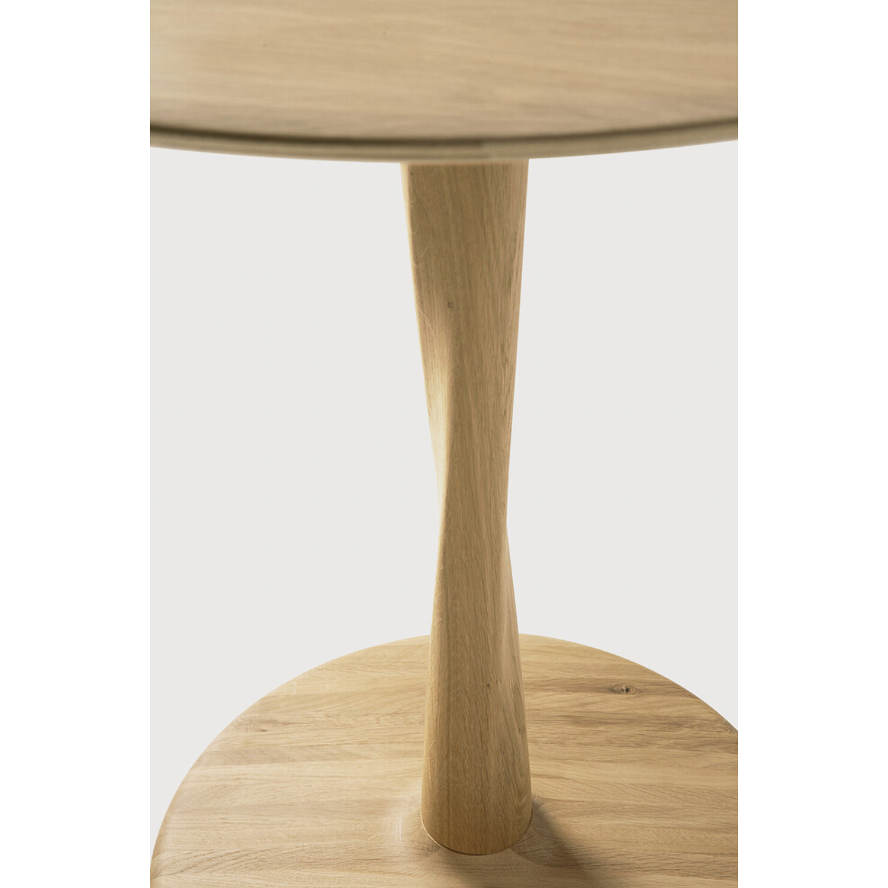Featuring Oak Round Torsion Dining Table by Ethnicraft at Amethyst Home. Airy with subtle complexities, this Oak Round Torsion Dining Table incorporates advanced woodworking techniques to create a light table top with a torsaded base of sculptural elegance -- sure to elevate the look for any dining or kitchen area. 
Material: Oak, 100% Solid WoodFinish: Varn.  Amethyst Home provides interior design, new home construction design consulting, vintage area rugs, and lighting in the Houston metro area.
