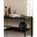 The deep surface of the Pentagon console is shaped by hand by skilled artisans. Natural mineral powders and color pigments blend to form the console's unique finish. We love how this piece's simple lines showcase the clean beauty of well-crafted metal work. We imagine this unique piece in your entry hall or behind your sofa where the two shelves offer so much space to display the items you love!  Dimensions: 59.5"w x 16"d x 30"h  Weight: 78 lbs  Material: Minerals Finish: Varnished 