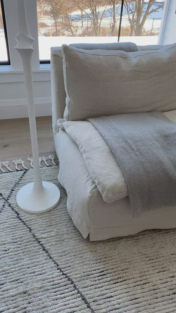 Load video: A casual, slipcovered chunky linen sectional by Cisco Brothers, the Laguna 2pc Sectional is the ultimate in casual luxury.  A down-filled seat cushion is supported by springs in a gentle, resting position.  Pair with a one-of-a-kind statement rug for a signature look. Shown in Otis White 100% linen.  Overall dimensions: 113&quot;w x 31&quot;h x 113&quot;d Seat Space: 96&quot;w x 96&quot;d x 16&quot;h