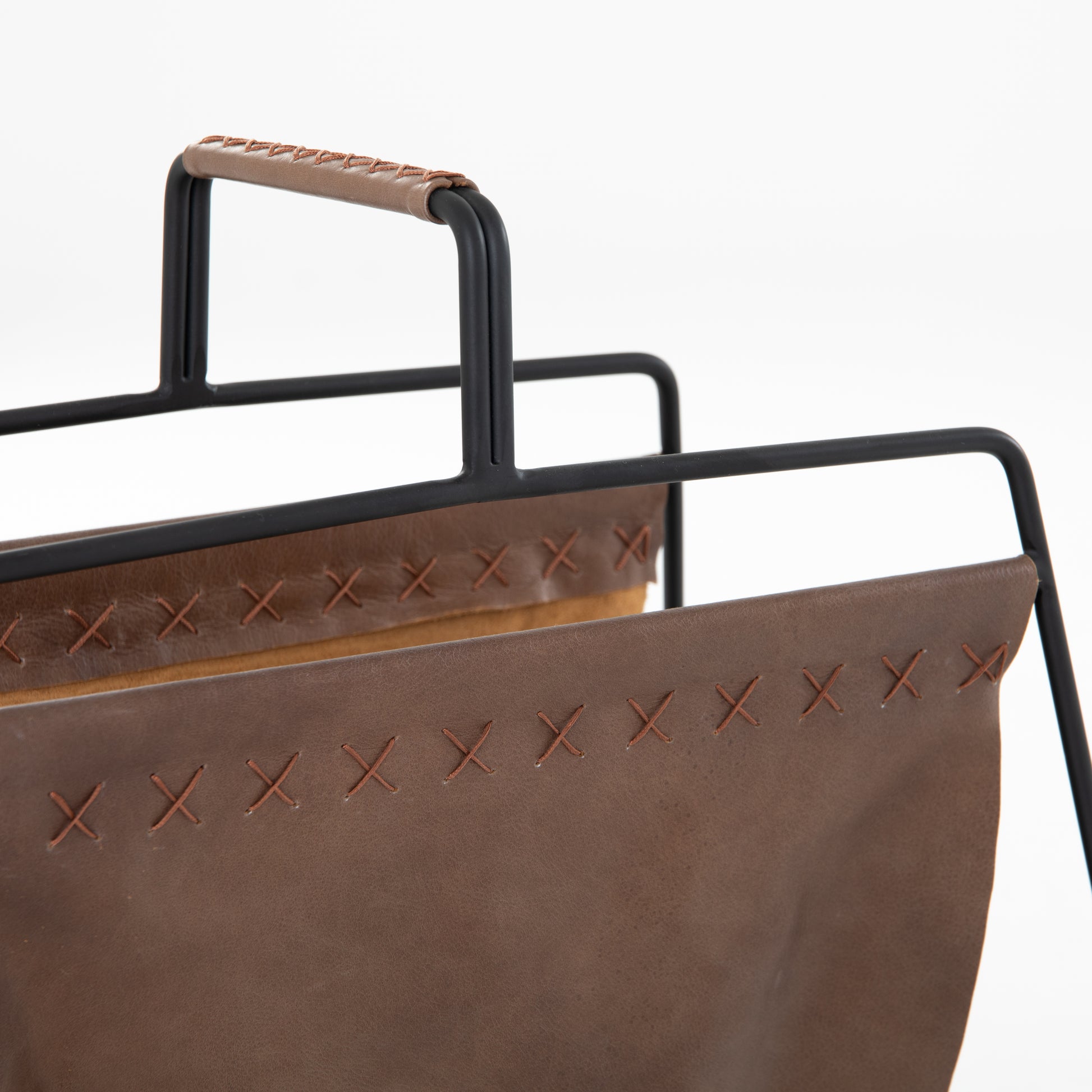 We love the cross-stitching details on this patina brown, top grain leather Aesop Magazing Rack. A gorgeous piece to place all your favorite magazines or important papers in, while also bringing a stylish mid-century vibe to your office or other space.  Overall Dimensions: 18.50"w x 11.75"d x 19.00"h Materials: Top Grain Leather, Iron Colors: Patina Brown, Smooth Jet Black