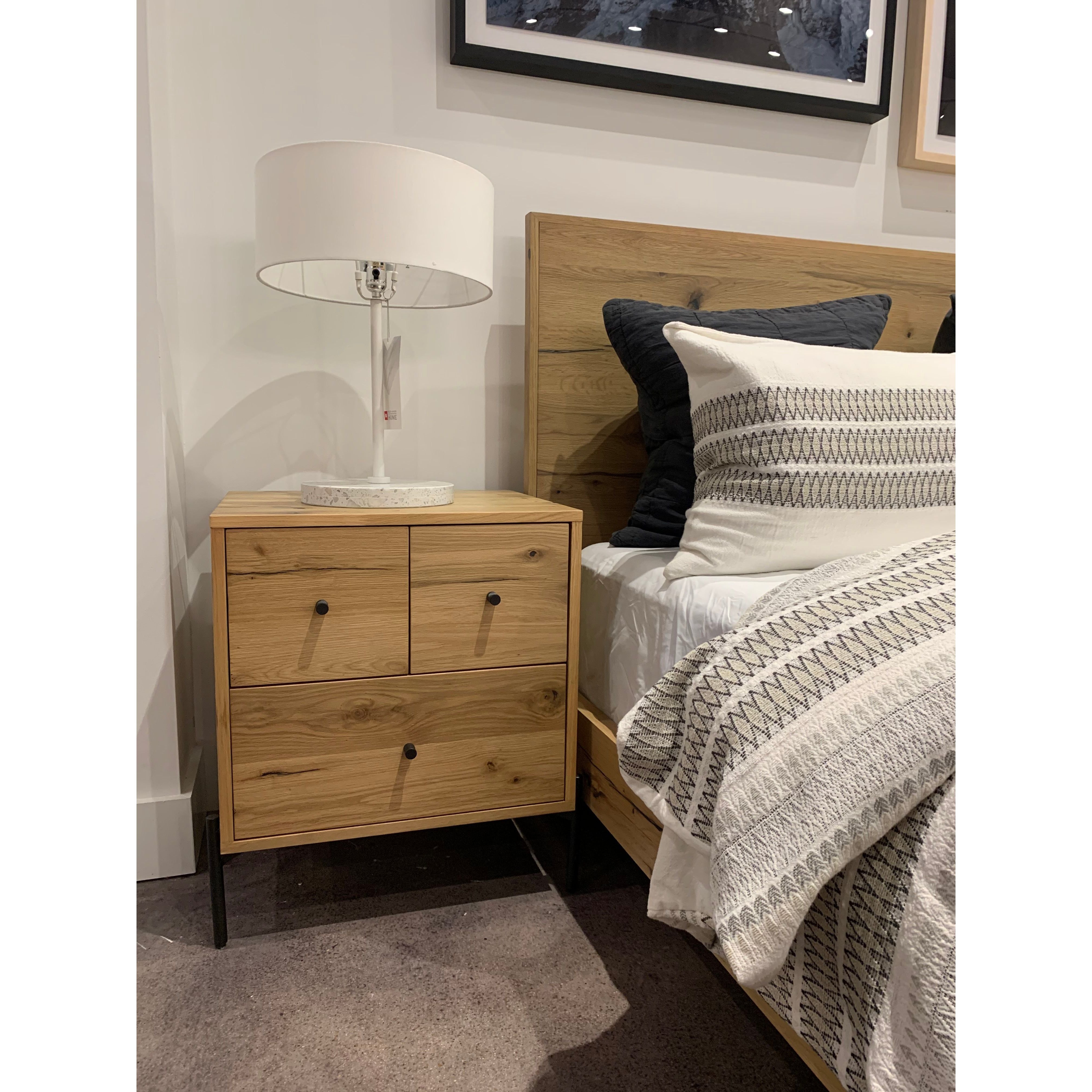 This Eaton Nightstand - Light Oak has a gorgeous, thick oak veneer with thin, iron legs. With one large drawer and two smaller drawers, this is the perfect nightstand to complete your bedroom.   Overall Dimensions: 23.50"w x 18.50"d x 26.00"h Colors: Dark Gunmetal, Light Oak Resin Materials: Iron, Thick Oak Veneer