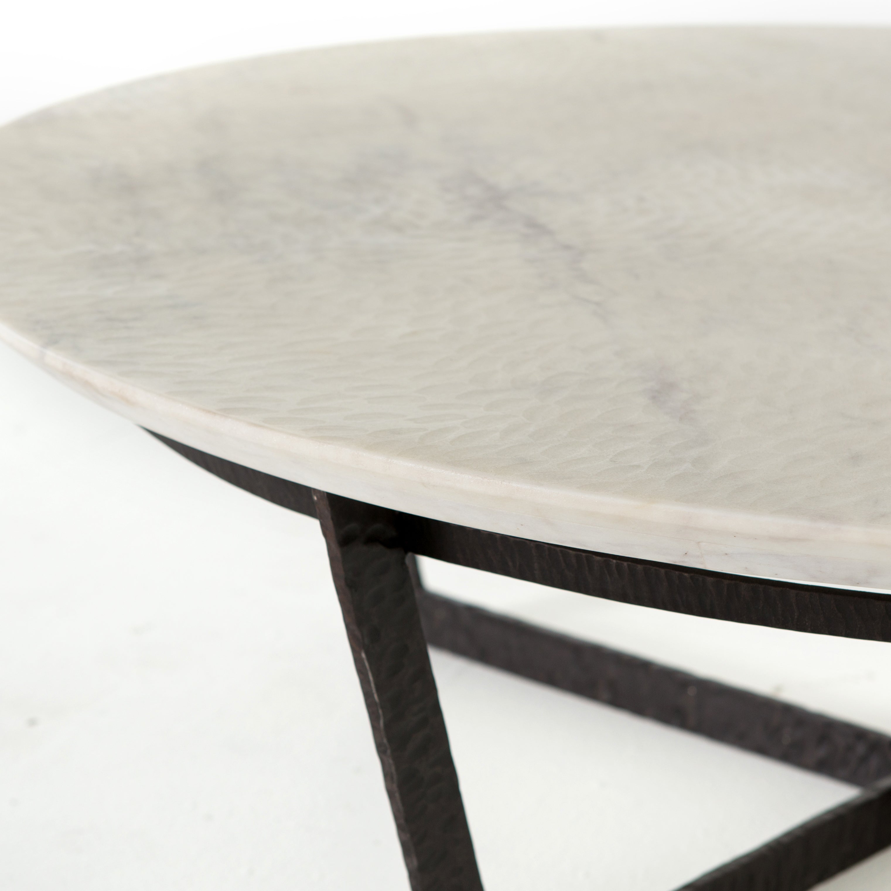 We love the textured top and geometric base of this Felix Round Coffee Table - Sandblasted White Marble. Place in your living room or lounge area to bring a sophisticated look to the space.  Overall Dimensions: 48.00"w x 48.00"d x 15.00"h Colors: Rustic Fossil, Sandblasted White Marble Materials: Iron, Marble Weight: 189.6 lb