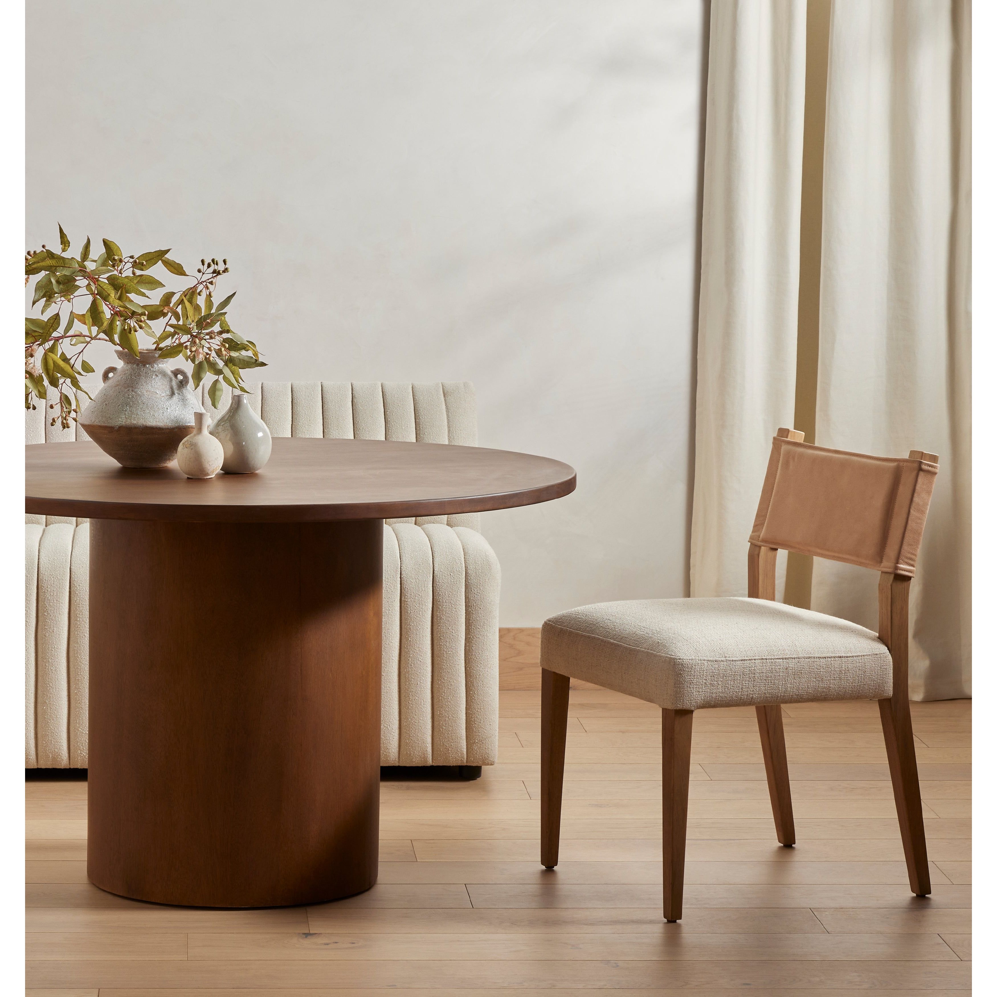 We love the mixed materials found on this Ferris Dining Chair - Winchester Beige. Solid parawood forms a slight, simple frame for squared seating upholstered in high-performance fabric. Tan top-grain leather backing takes this modern-minded dining chair to the next level.  Overall Dimensions: 20.00"w x 21.75"d x 32.00"h