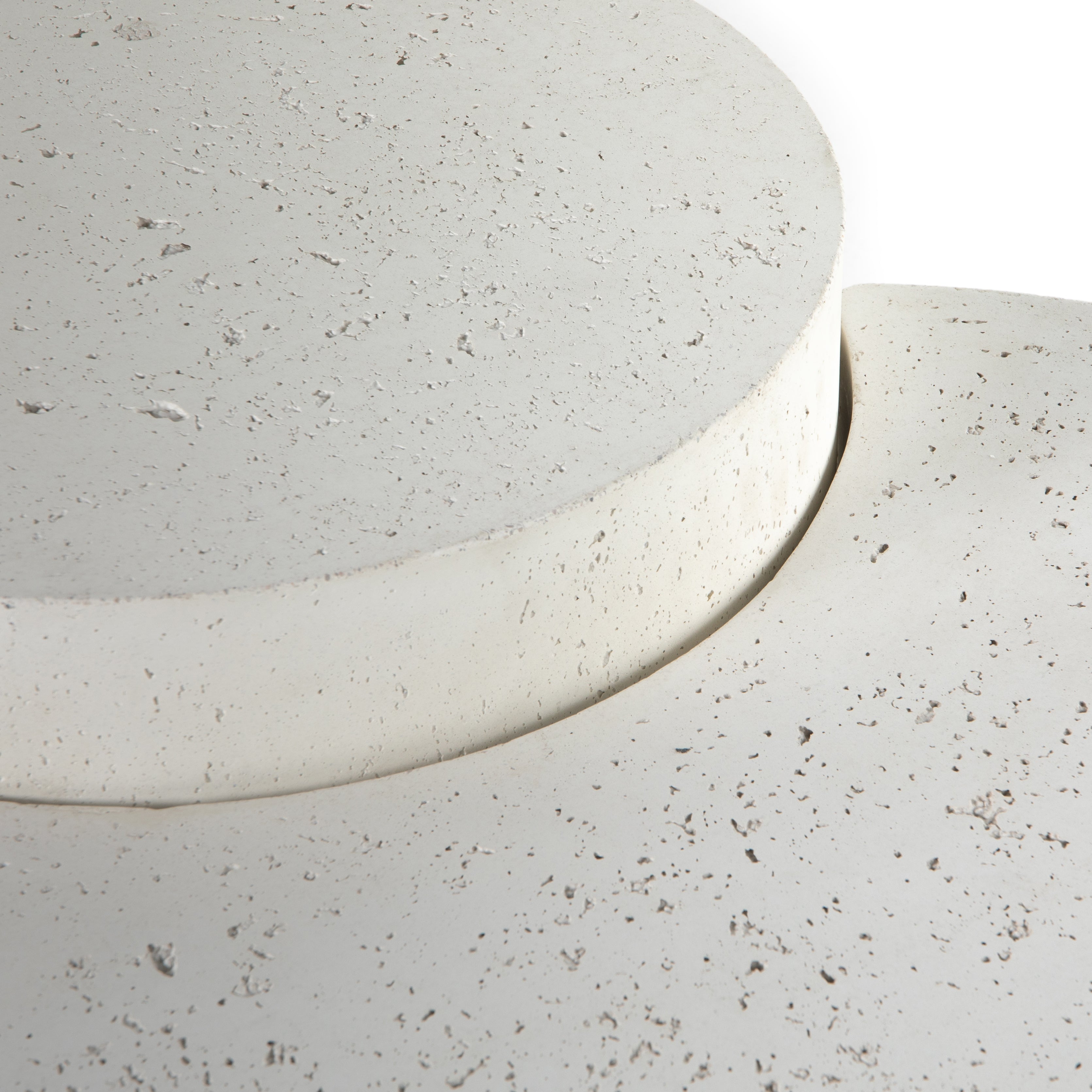 Made from white-finished concrete with deep, textured pitting, this Meza Nesting Coffee Table - Textured White is sturdy and beautiful. Inspired by mid-century coral décor, this nesting coffee table features two tiers for a layered look with modernity.  Overall Dimensions: 43.75"w x 28.25"d x 19.00"h