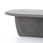 This Naya Outdoor Coffee Table is modern and curve-driven. Dark grey concrete forms a rounded rectangle top with bullnose edging, reminiscent of a shapely surfboard.  Cover or store inside during inclement weather.  Overall Dimensions: 46.00"w x 28.00"d x 16.00"h