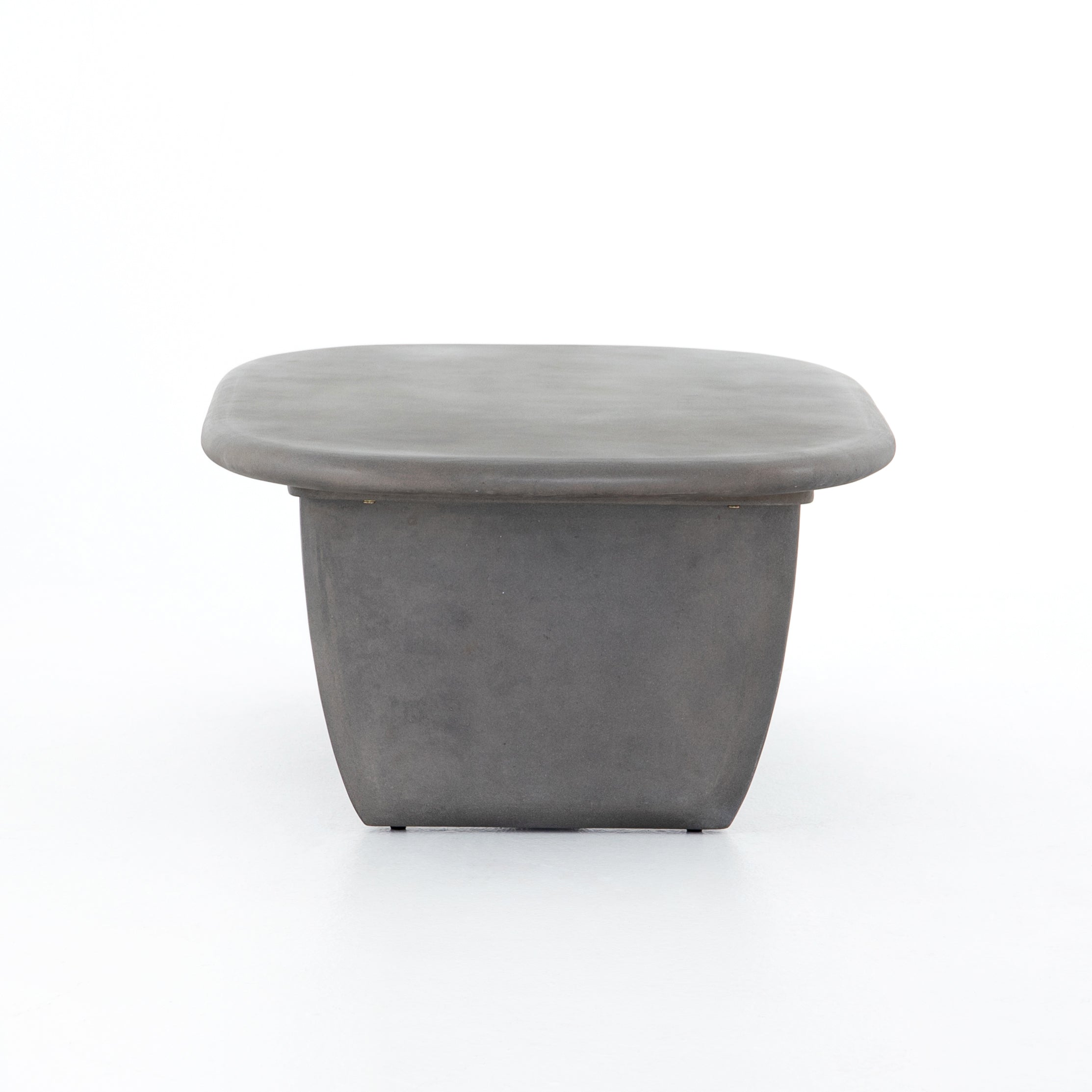 This Naya Outdoor Coffee Table is modern and curve-driven. Dark grey concrete forms a rounded rectangle top with bullnose edging, reminiscent of a shapely surfboard.  Cover or store inside during inclement weather.  Overall Dimensions: 46.00"w x 28.00"d x 16.00"h