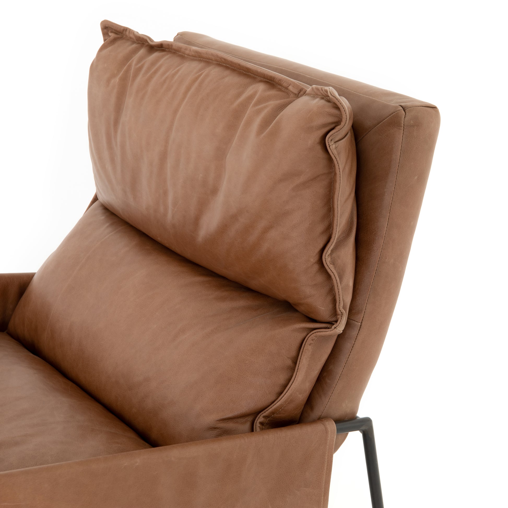 A nod to relaxed modernism, playing up the natural depth of exclusive top-grain leather, with buckle details and low-slung styling crafting the hippest of vibes.  Overall Dimensions: 28.00"w x 37.00"d x 35.00"h Seat Depth: 22" Seat Height: 20" Arm Height from Floor: 23.5" Arm Height from Seat: 3.5"  Colors: Waxed Ebony, Chaps Saddle Materials: Iron, Top Grain Leather