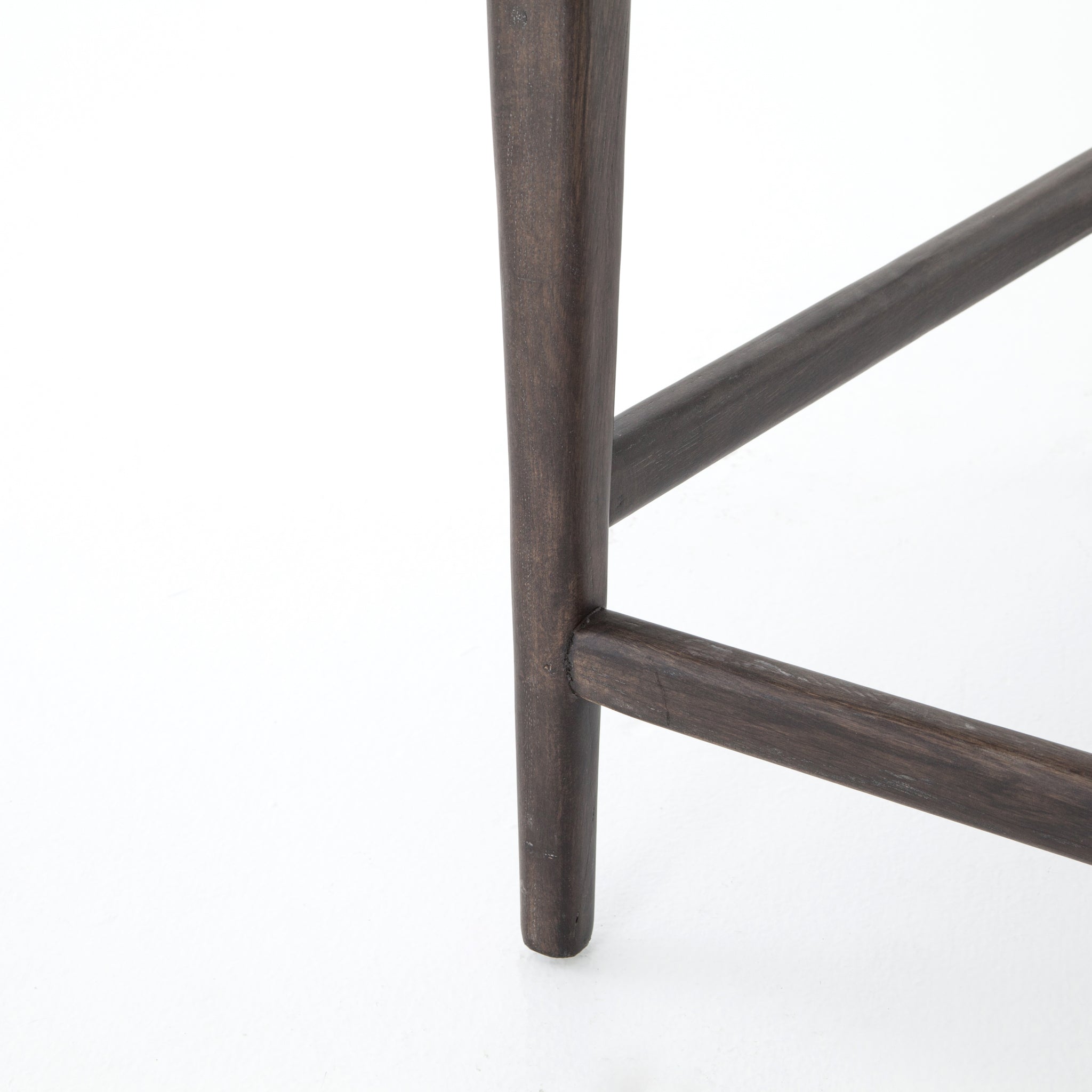 The Tyler Bar + Counter Stool - Ebony makes counter seating stylish with an angular, dark and smoky birch frame, a deep seat, and a striking, low-slung back. The stool is comfortable for long dinners and conversations with a covered black, top-grain leather seat and back.