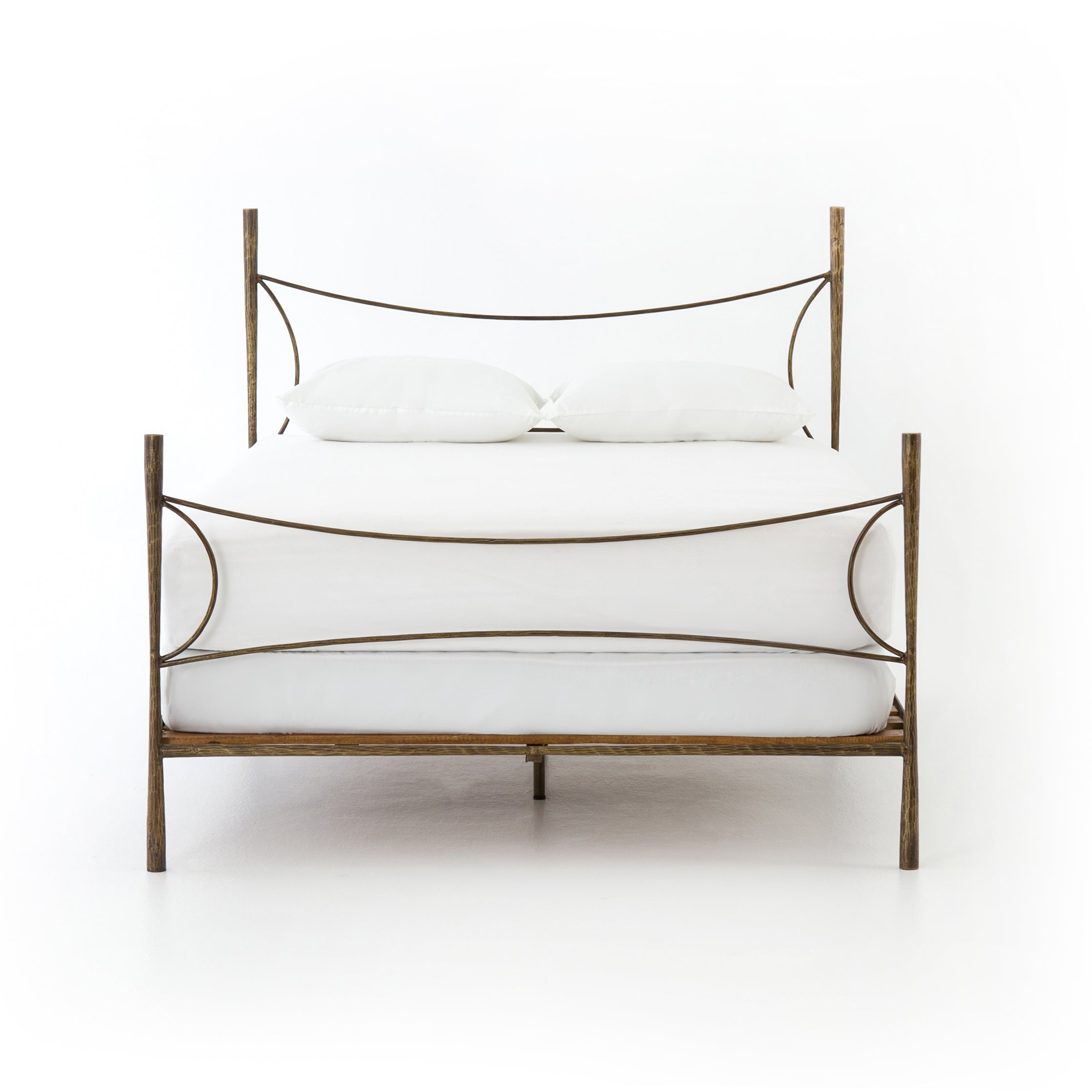 Beguiling curves soften hard materials for marked drama with this Westwood Bed. Slim, hammered iron is finished in antique brass for depth that defies this frame's feminine air. Low-profile box spring recommended.