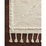 A new take on Moroccan style rugs, the Iman Beige/Ivory Rug from Loloi is hand-knotted of 100% wool pile by skilled artisans. The surface features linear and braided details, creating tonal variations that make each piece unique. Plus, each design is finished with a playful fringe.  Hand Knotted 100% Wool Pile IMA-05 Beige / Ivory