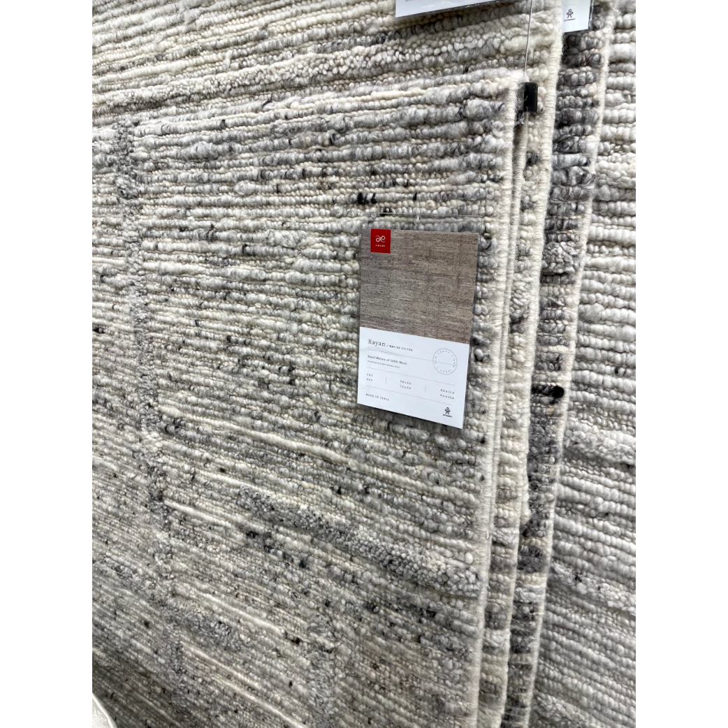 Hand-woven of 100% wool in India, the Rayan Silver Area Rug sets the tone for a calming atmosphere. Each design is crafted of textural highs and lows paired with neutral tones to create and engaging understatement. The perfect rug for your bedroom, office, or other medium traffic area.   Hand Woven 93% Wool | 5% Cotton | 2% Other Fibers Pile RAY-02 Silver