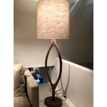 The Urbino Walnut Lamp is crafted from sustainably harvested hardwood by Verellen in North Carolina. The unique shape of the body paired with the oatmeal shade complements any room   Base: 16"w x 8"d x 62"h Overall Height: 76"h